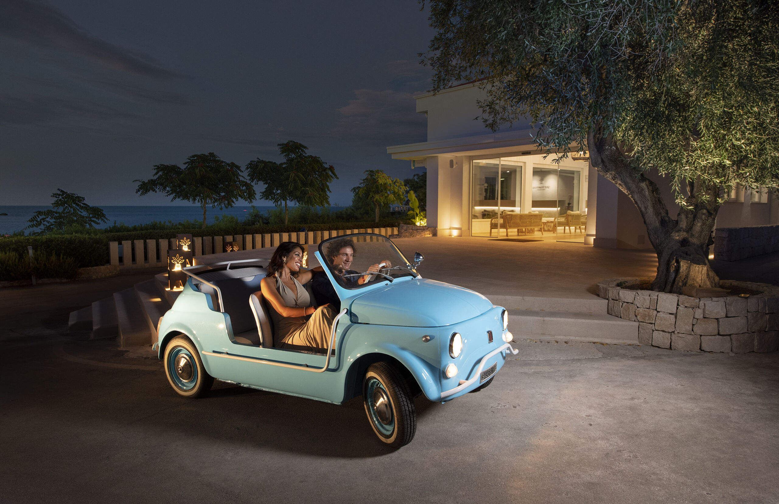 Fiat 500 d'epoca davanti alla villa illuminata di sera