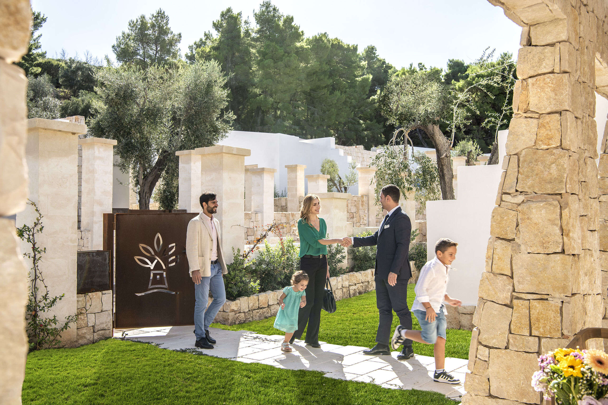 Famiglia all'ingresso in pietra di una villa del resort