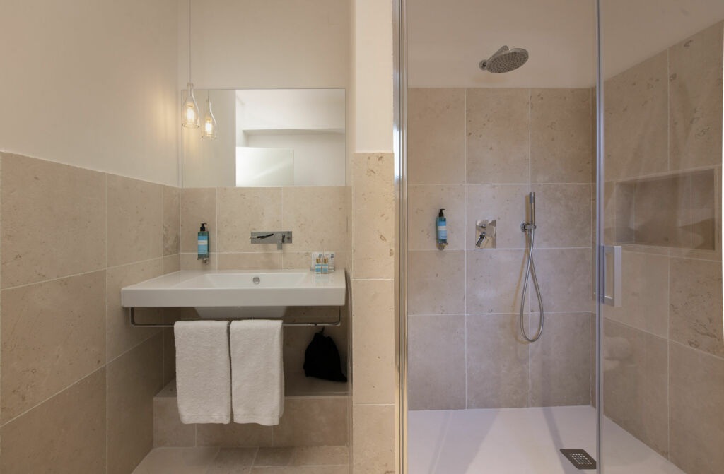 Bagno della camera con doccia e lavabo beige