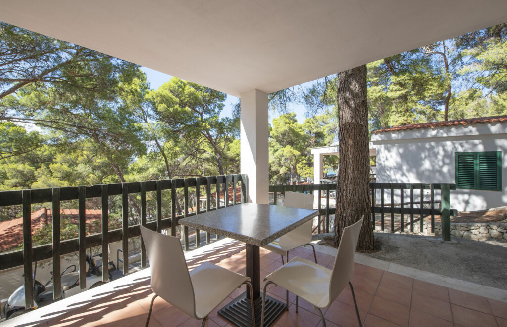 Terrazzo del residence con tavolo e pini